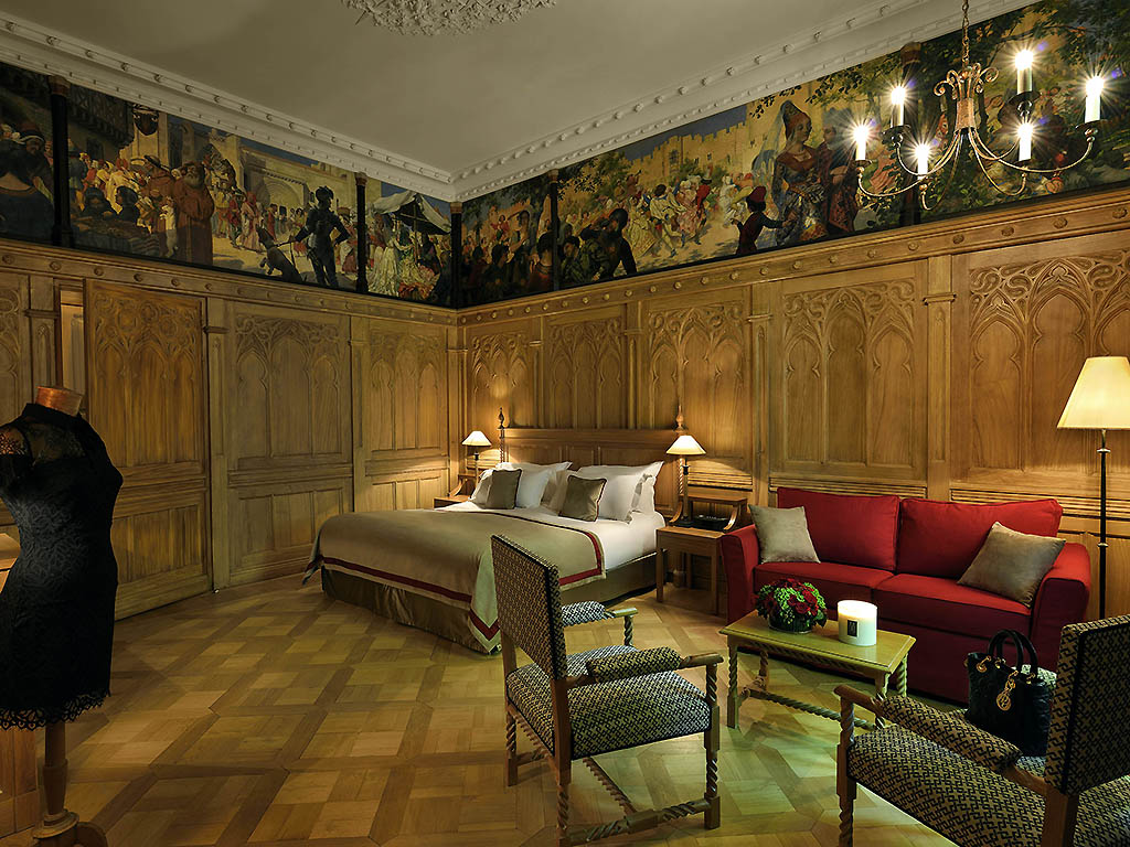 a room with a bed and chairs
