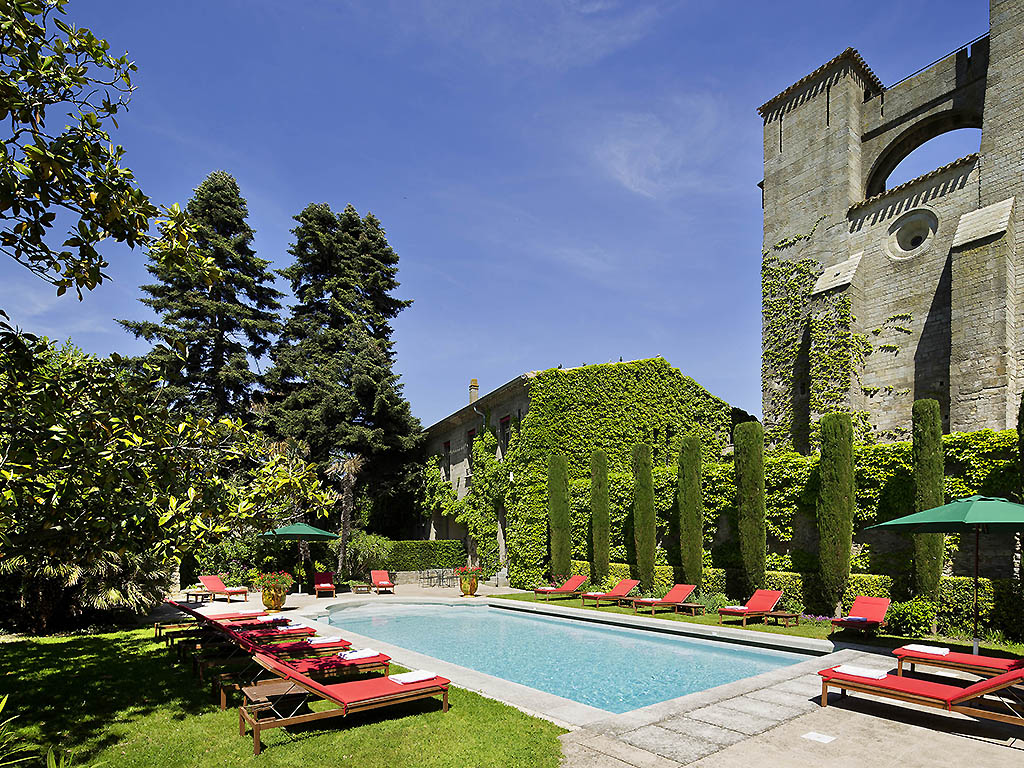 a pool with lounge chairs and a building in the background
