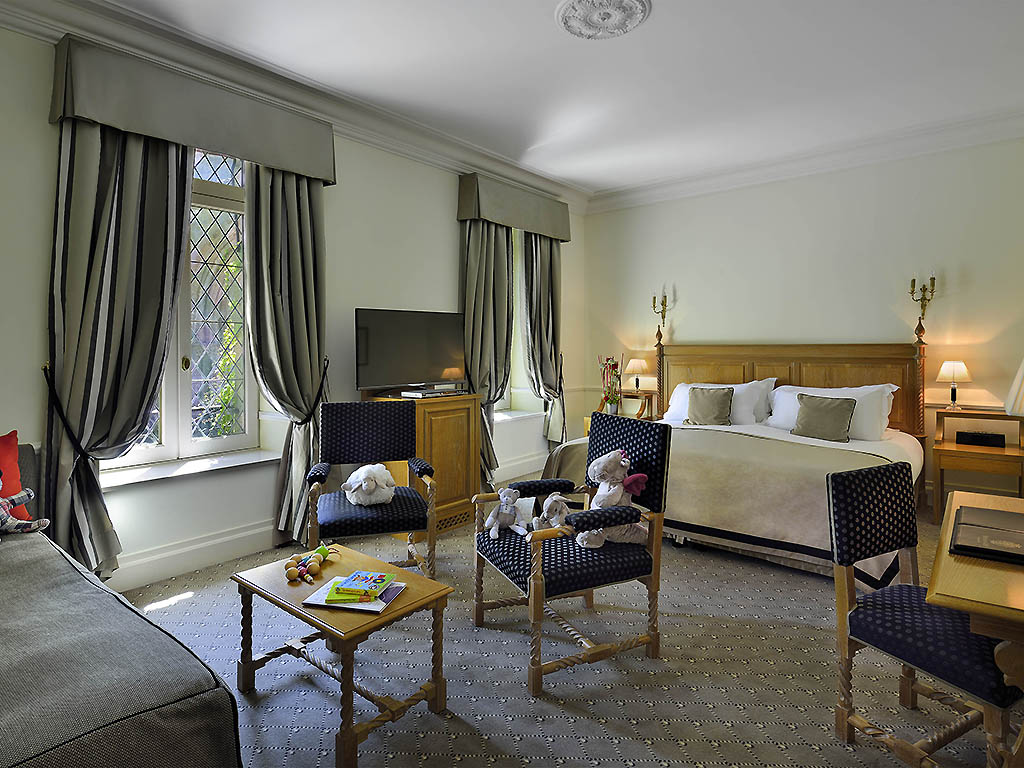 a room with a bed and chairs