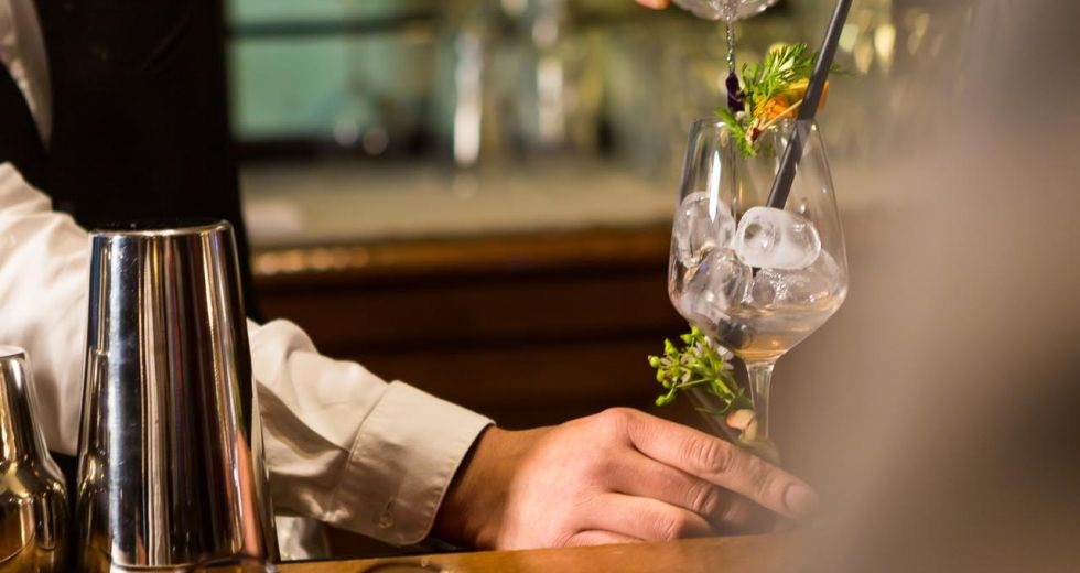 a person pouring a drink into a glass