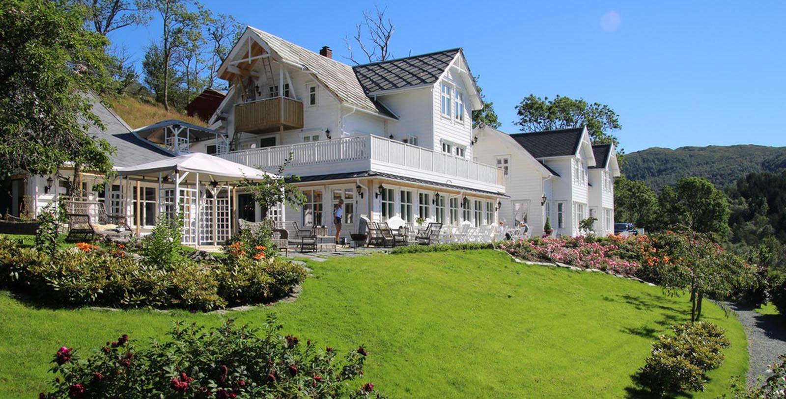 a large white house with a lawn and flowers