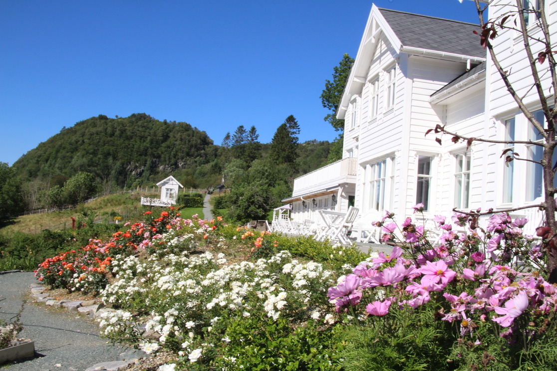 a white house with flowers in front of it
