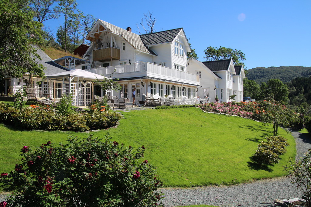 a large white house with a lawn and flowers