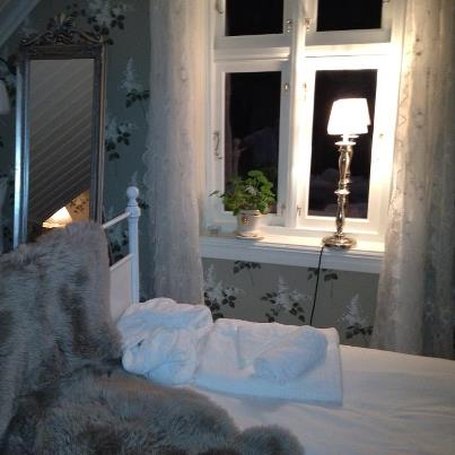 a bed with a blanket and a lamp in front of a window