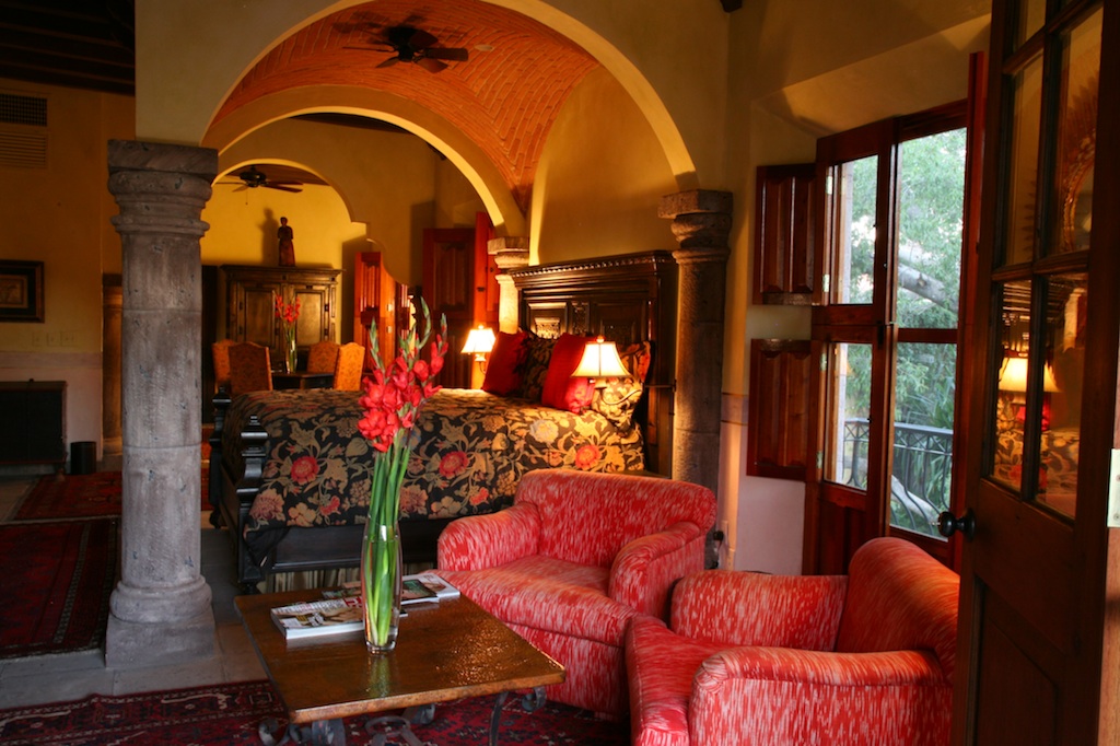 a room with a bed and chairs