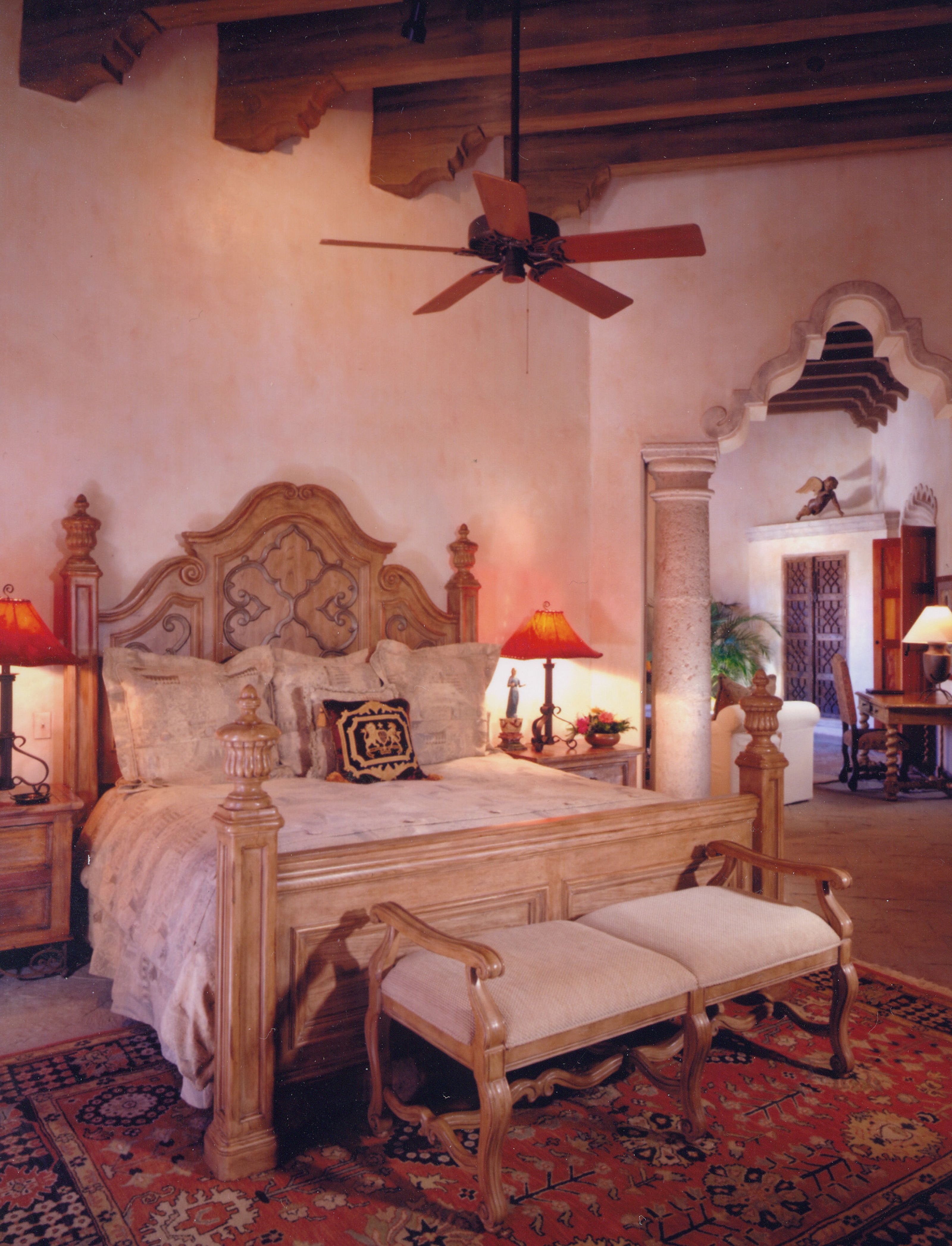 a bedroom with a large bed and a fan