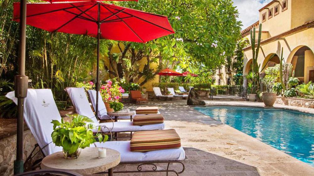 a pool with chairs and umbrellas