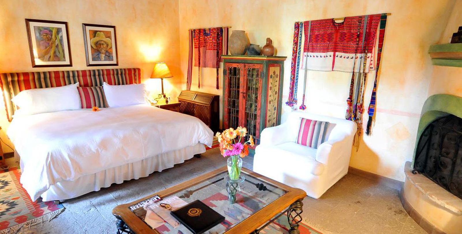 a room with a bed and chairs