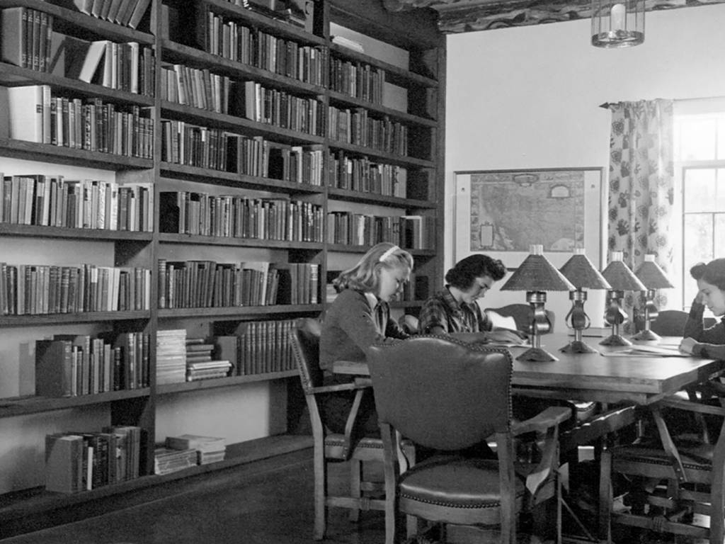 a group of people sitting at a table in a library
