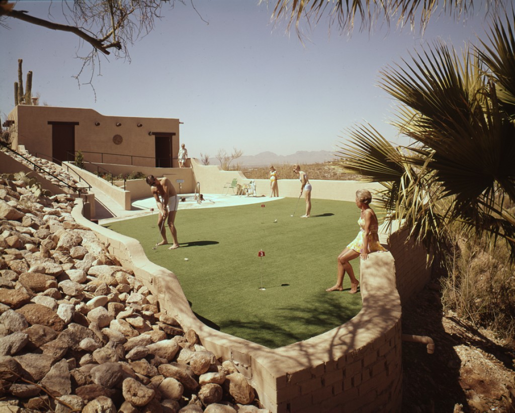 a group of people playing golf on a green field