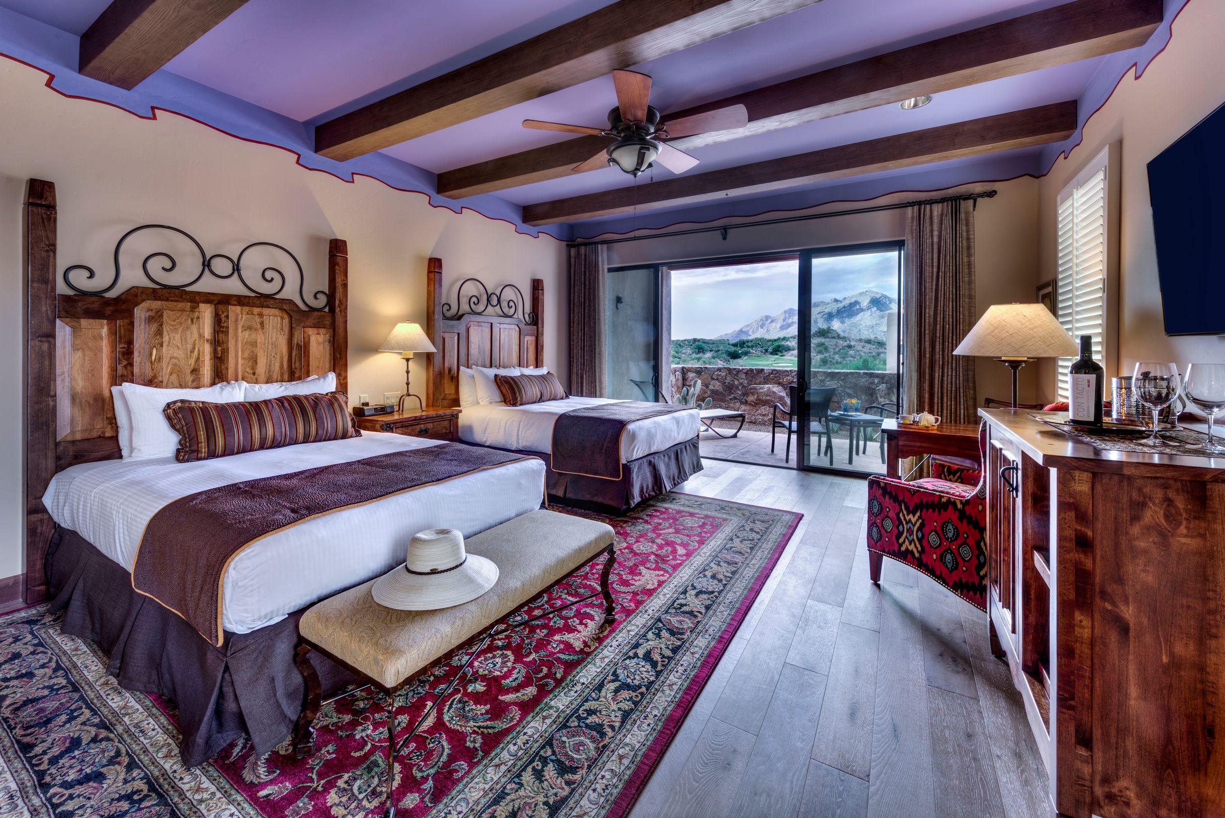 a room with two beds and a table with a window