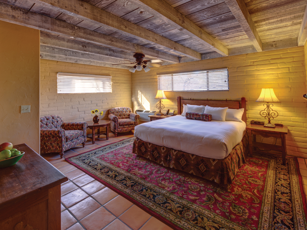 a bedroom with a bed and chairs