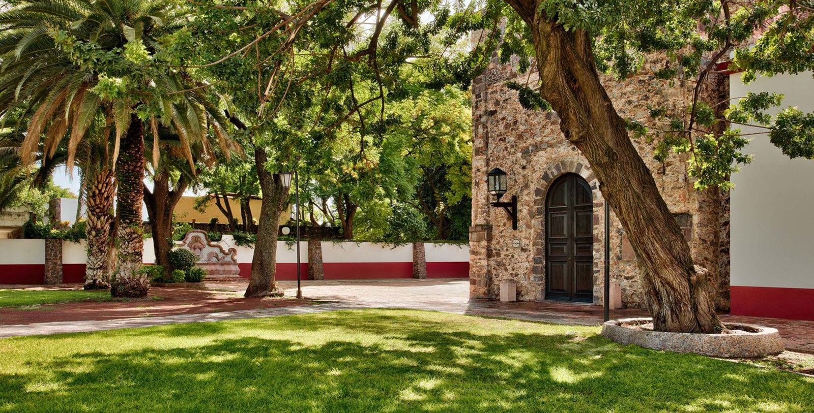 a stone building with a door and a lawn