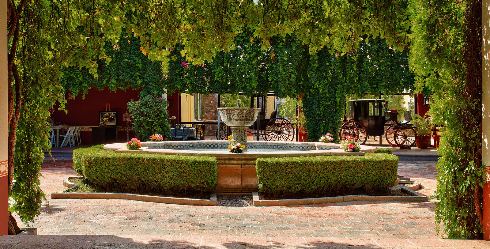 a fountain with a horse carriage in the background
