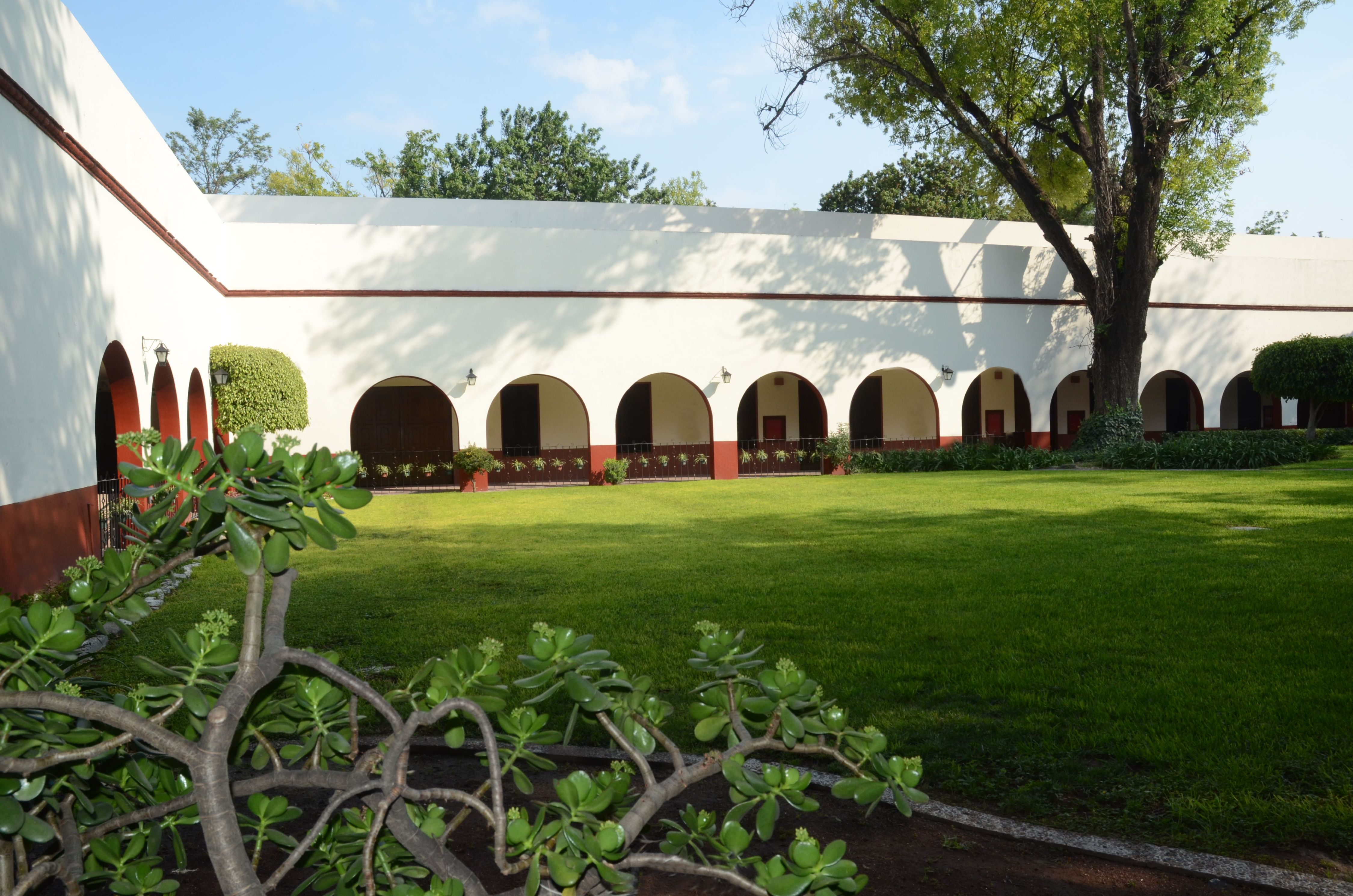 a white building with arches and a lawn