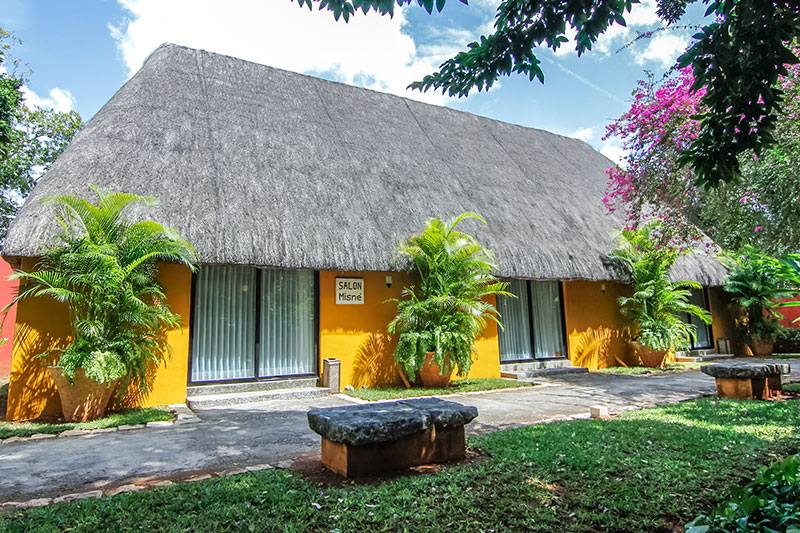 a yellow building with a thatched roof