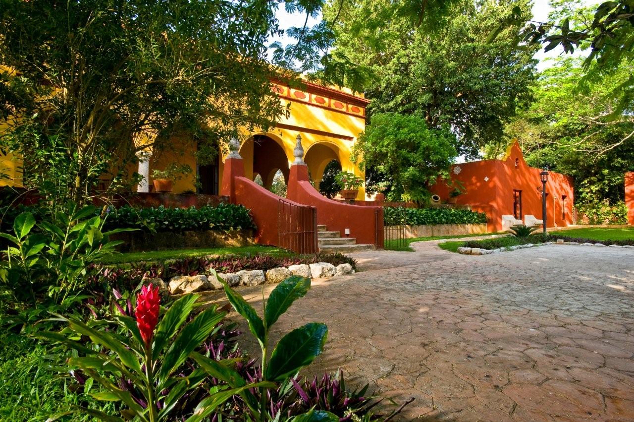 a yellow building with a red staircase and trees