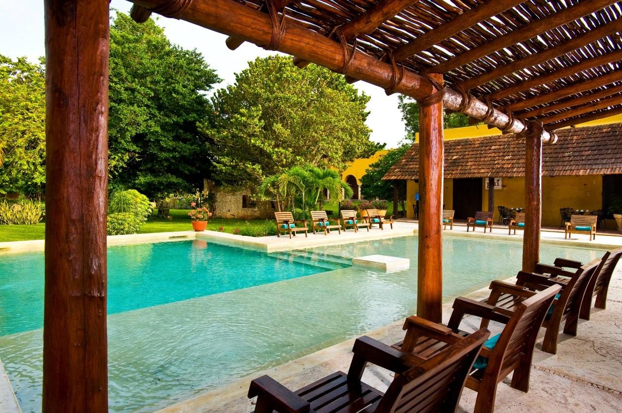 a pool with chairs and a wooden structure