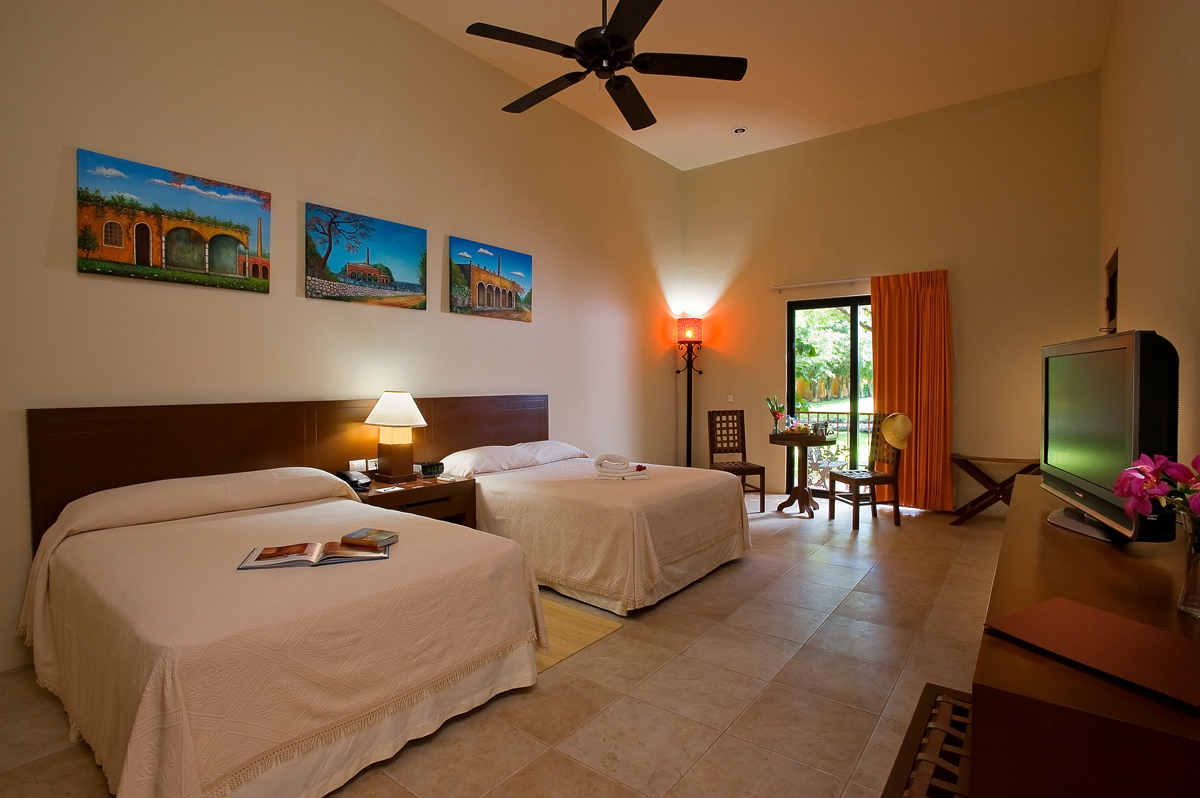 a room with two beds and a ceiling fan