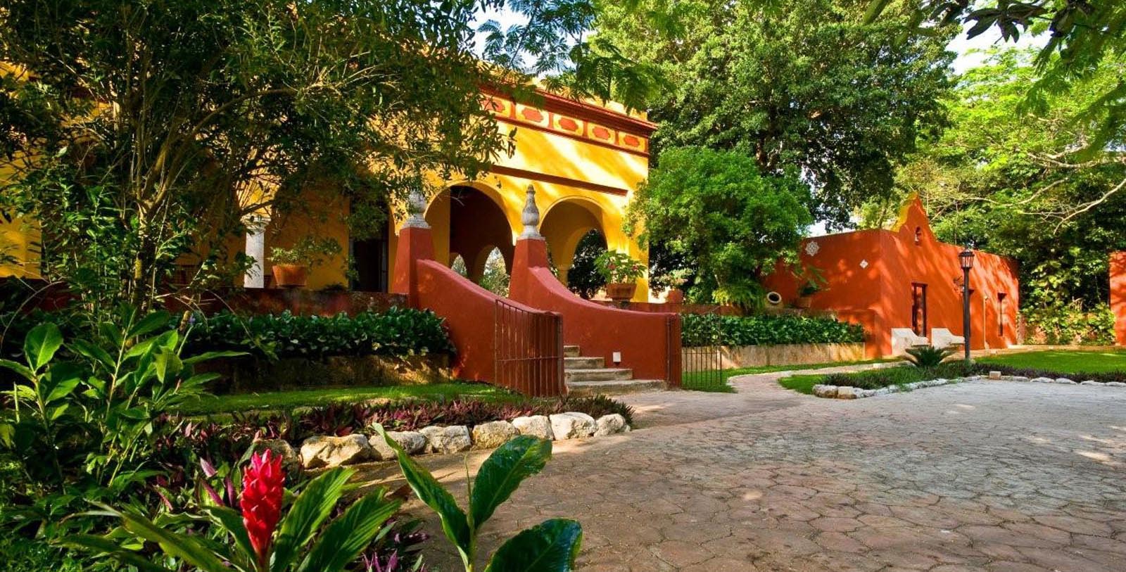 a yellow building with red walls and a red staircase
