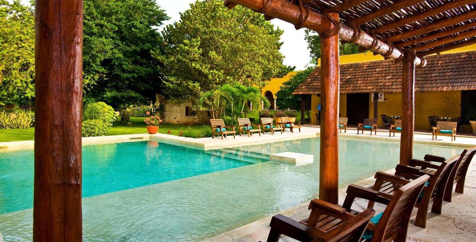 a pool with chairs and a wooden structure