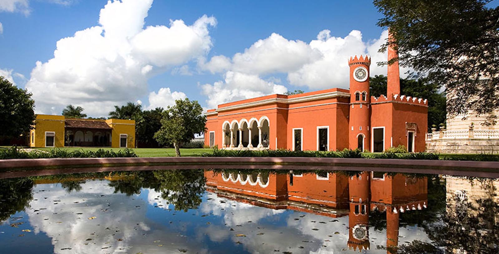 a building with a clock tower and a pond