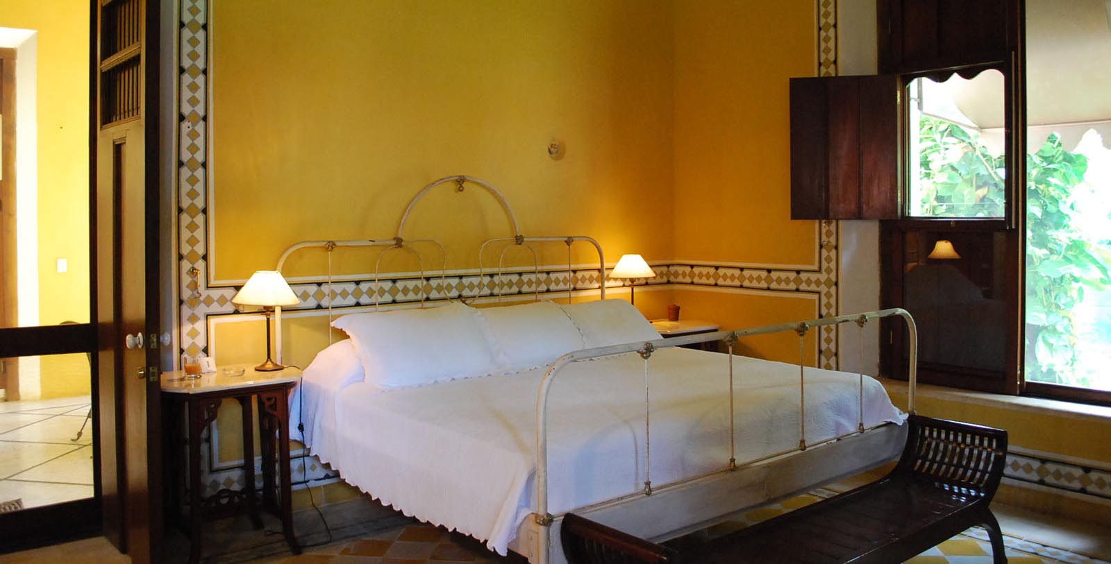 a bed with white sheets and lamps