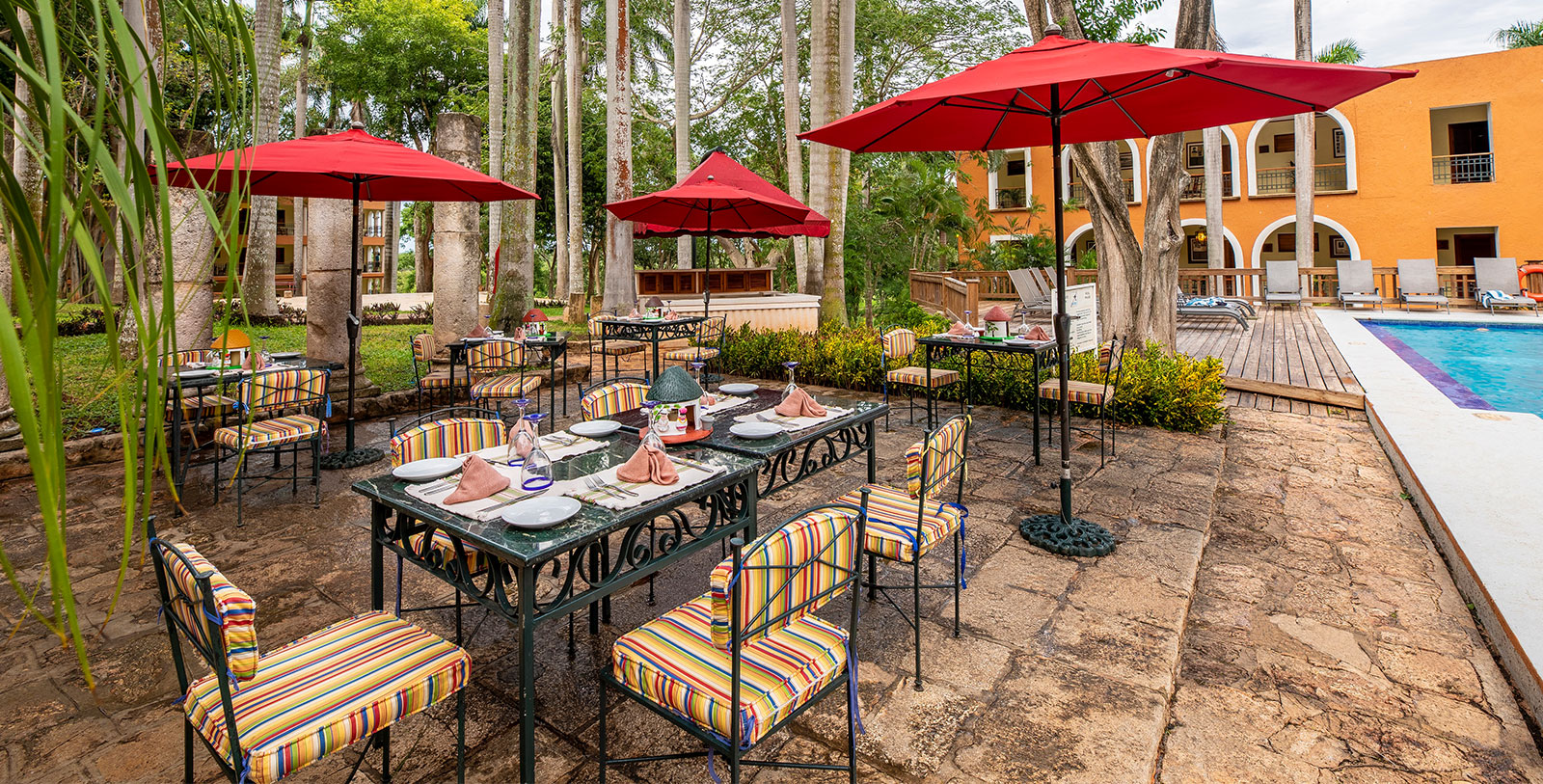 a table and chairs with red umbrellas