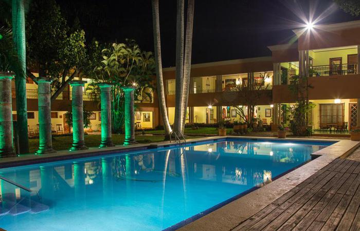a pool with trees and a building in the background