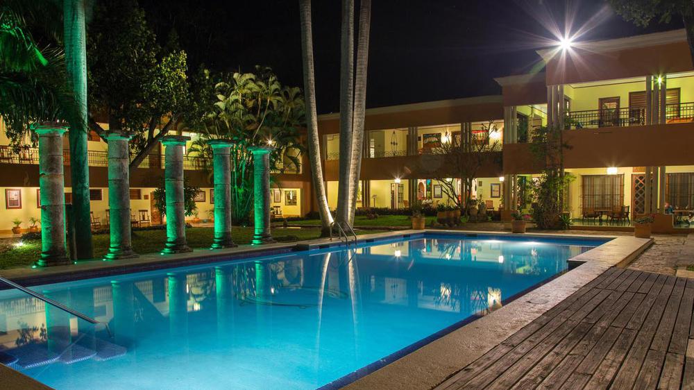a pool with trees and a building in the background