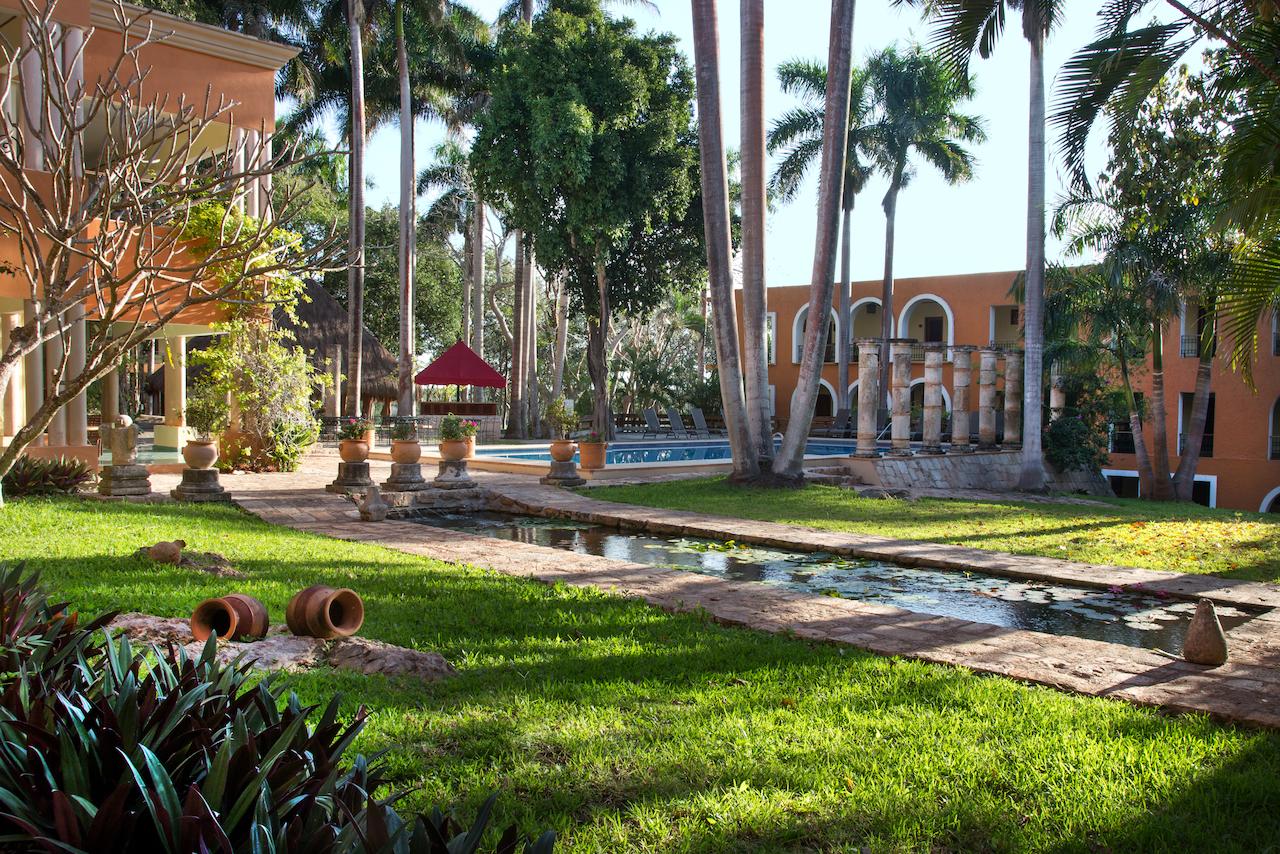 a pool in a courtyard with palm trees and a building