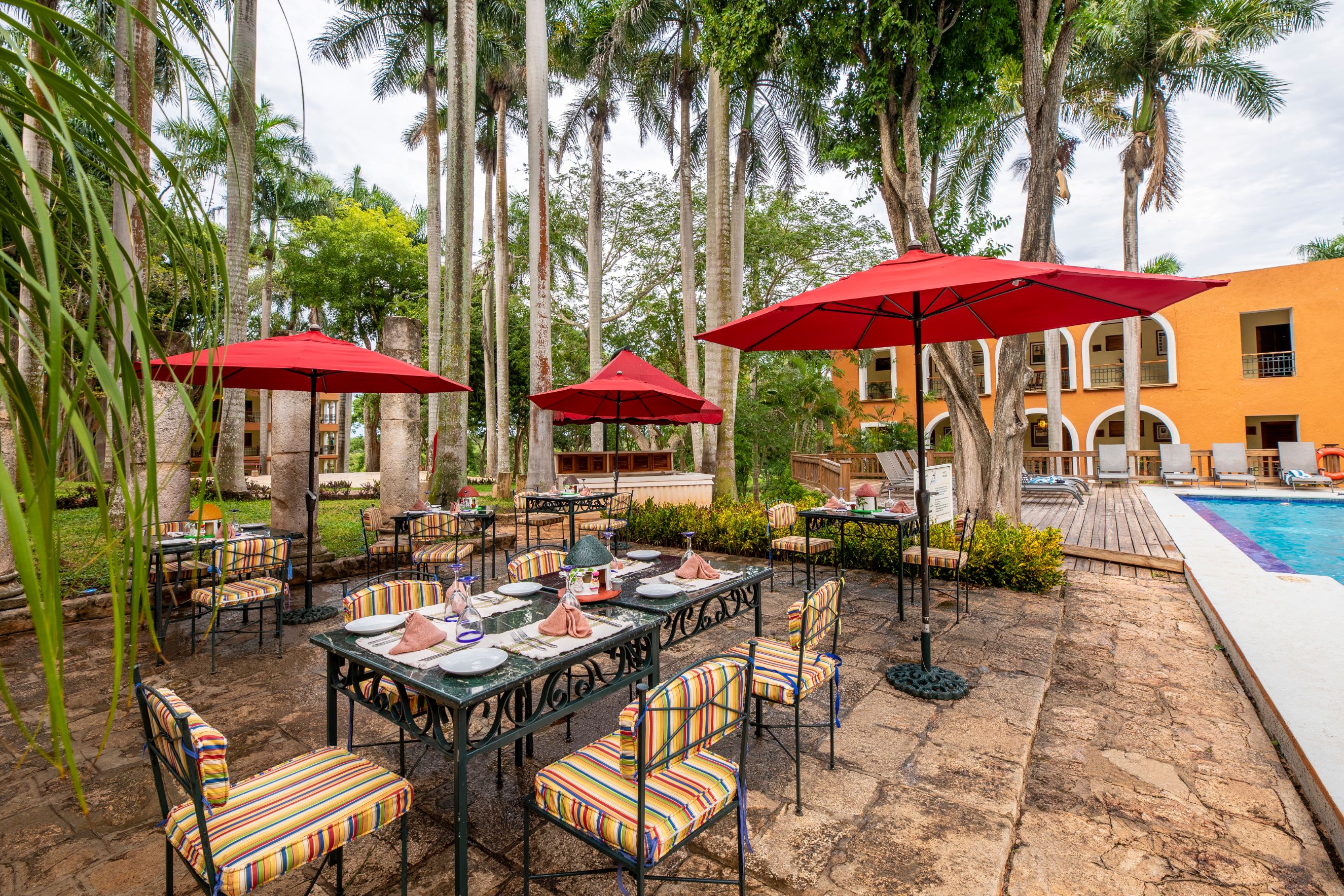 a table and chairs with red umbrellas