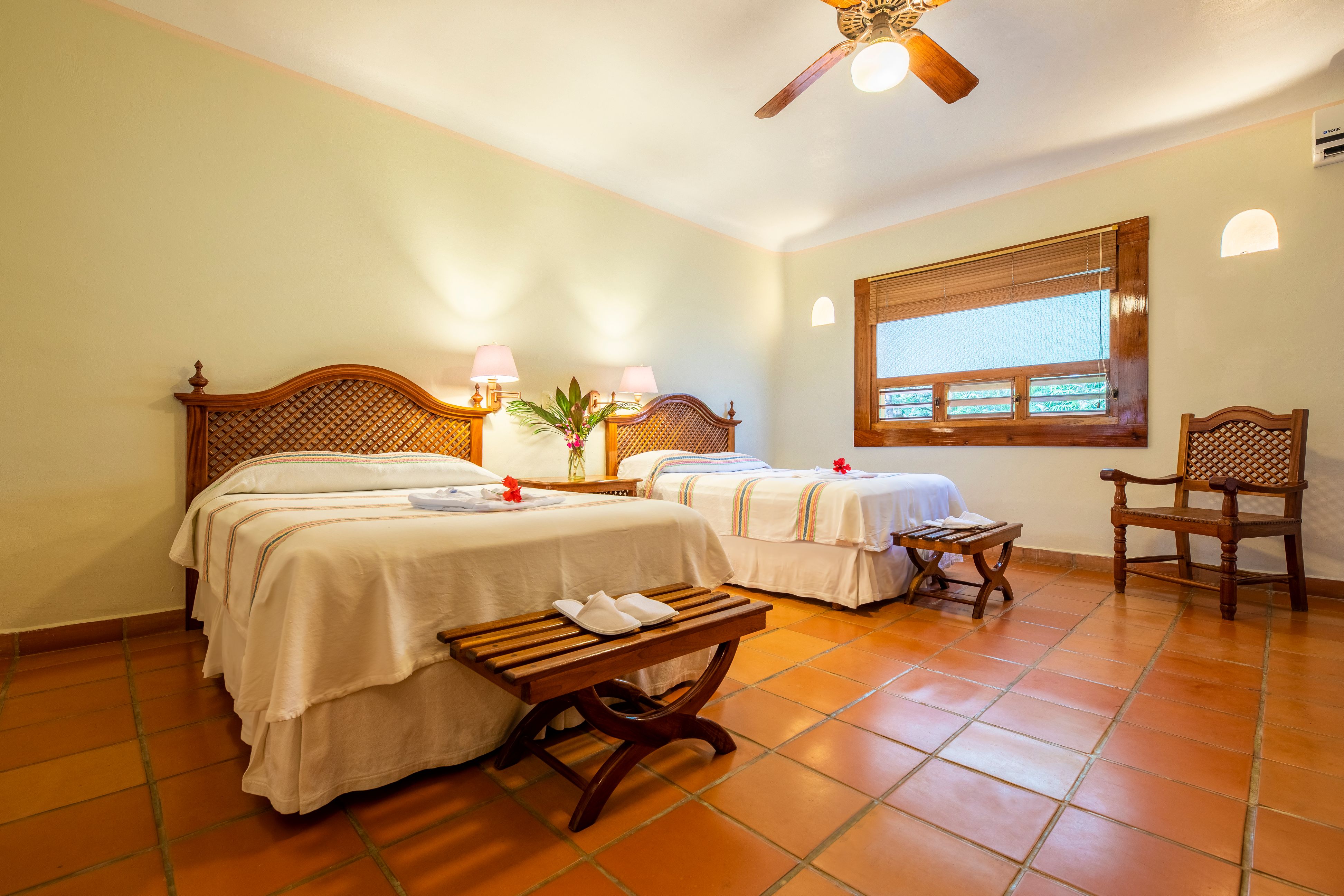 a room with two beds and a fan
