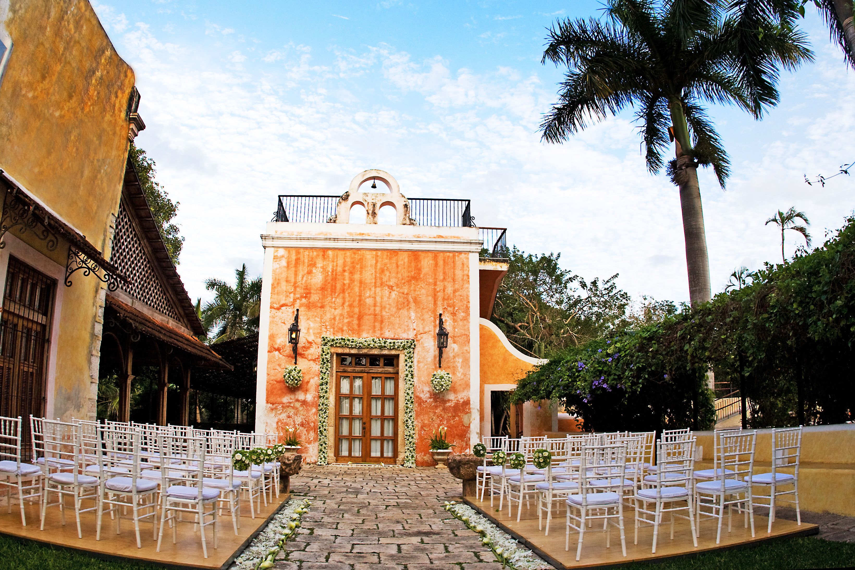 a building with white chairs and trees