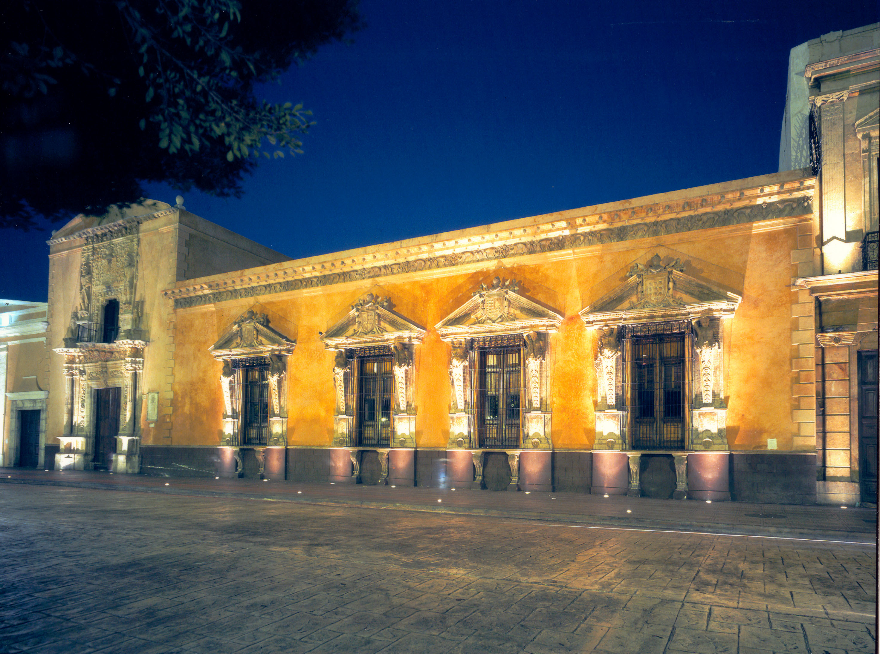 a building with many windows and a street at night