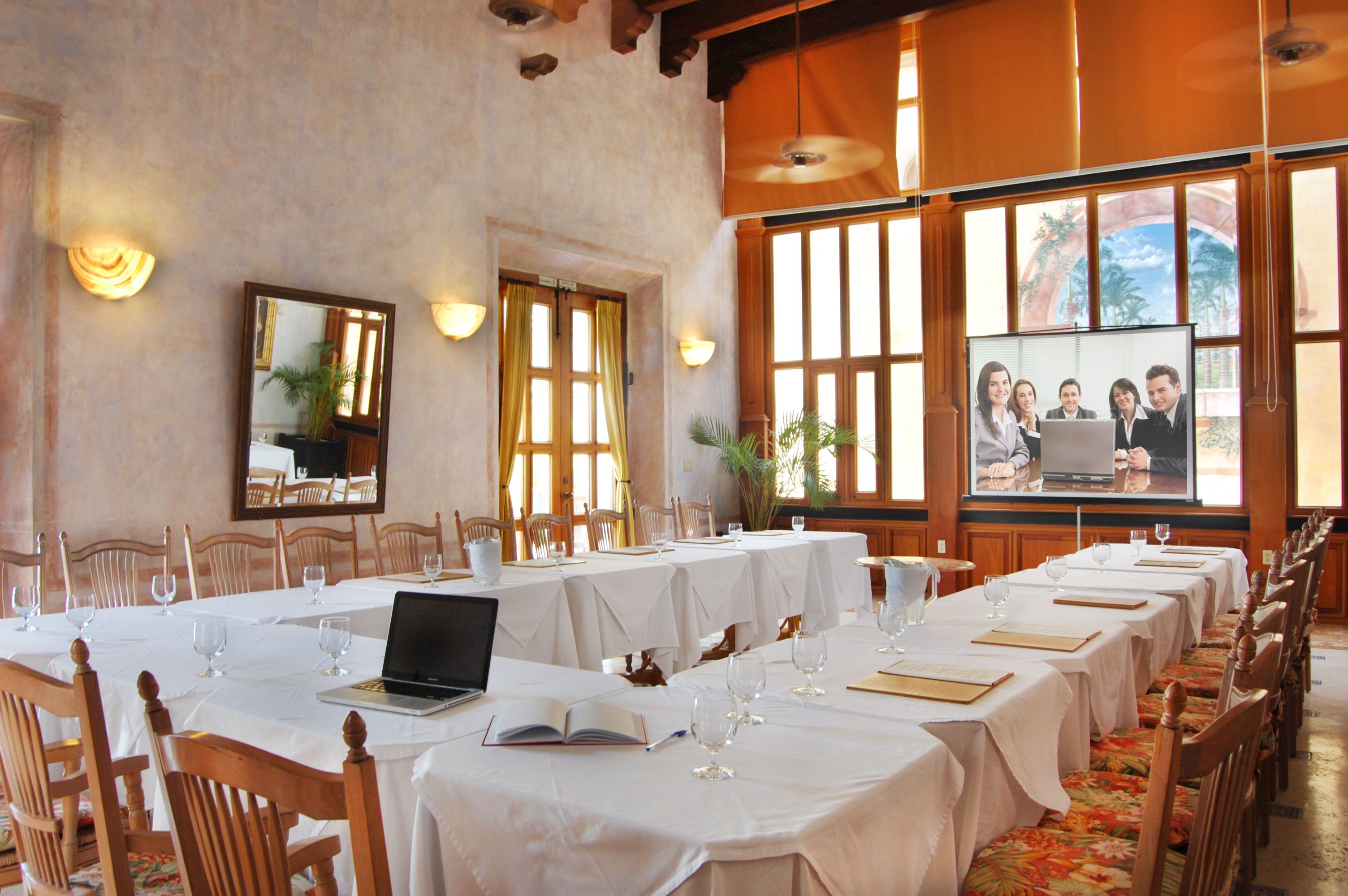 a room with tables and chairs with laptops and glasses