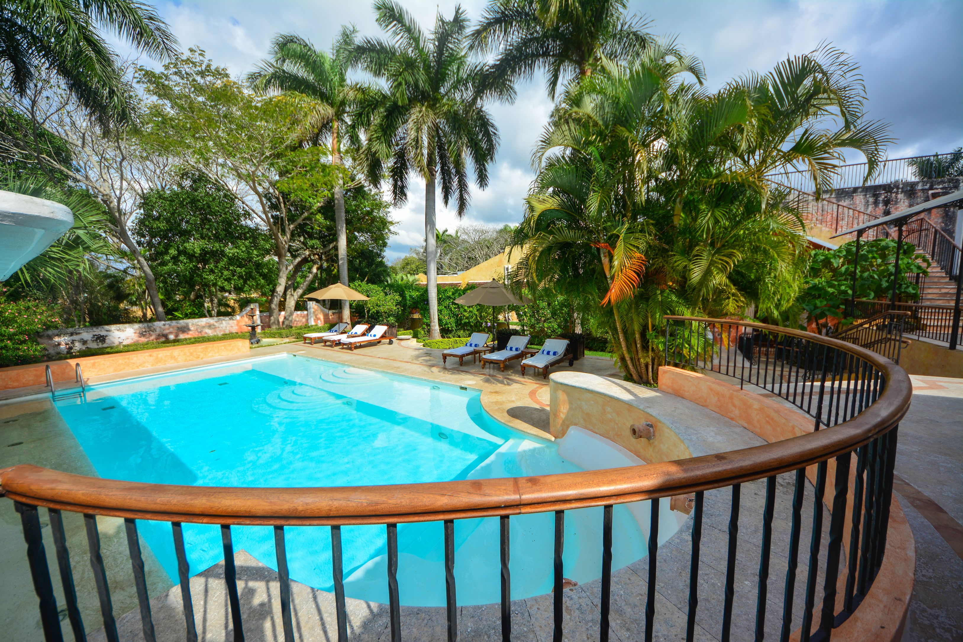 a pool with lounge chairs and palm trees