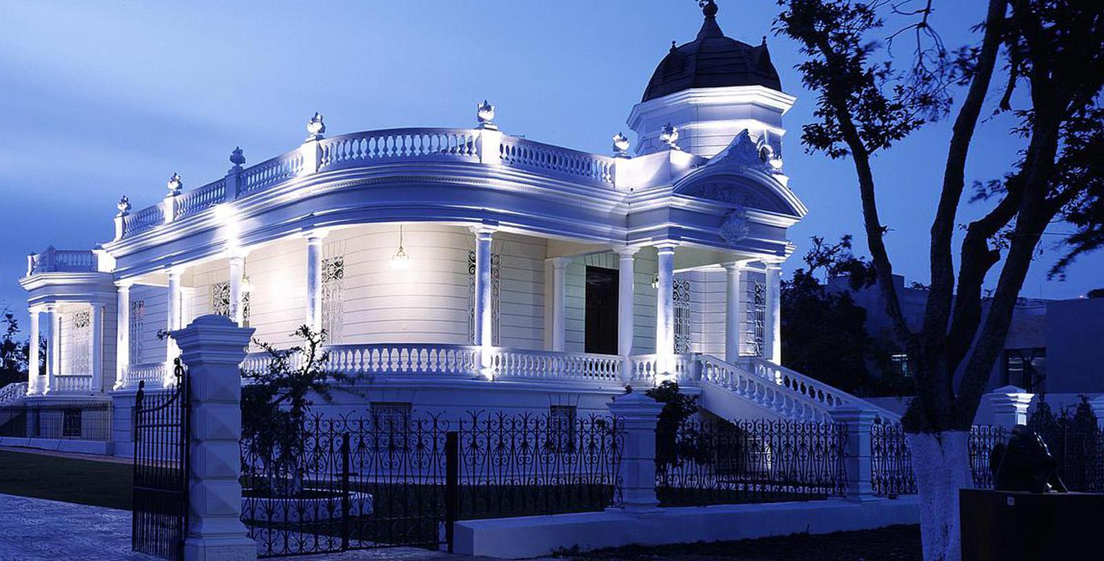 a white house with a black fence