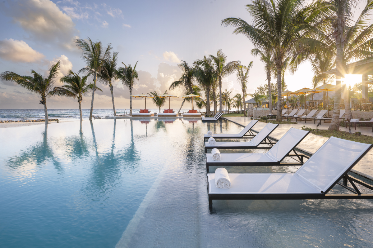 a pool with lounge chairs and palm trees