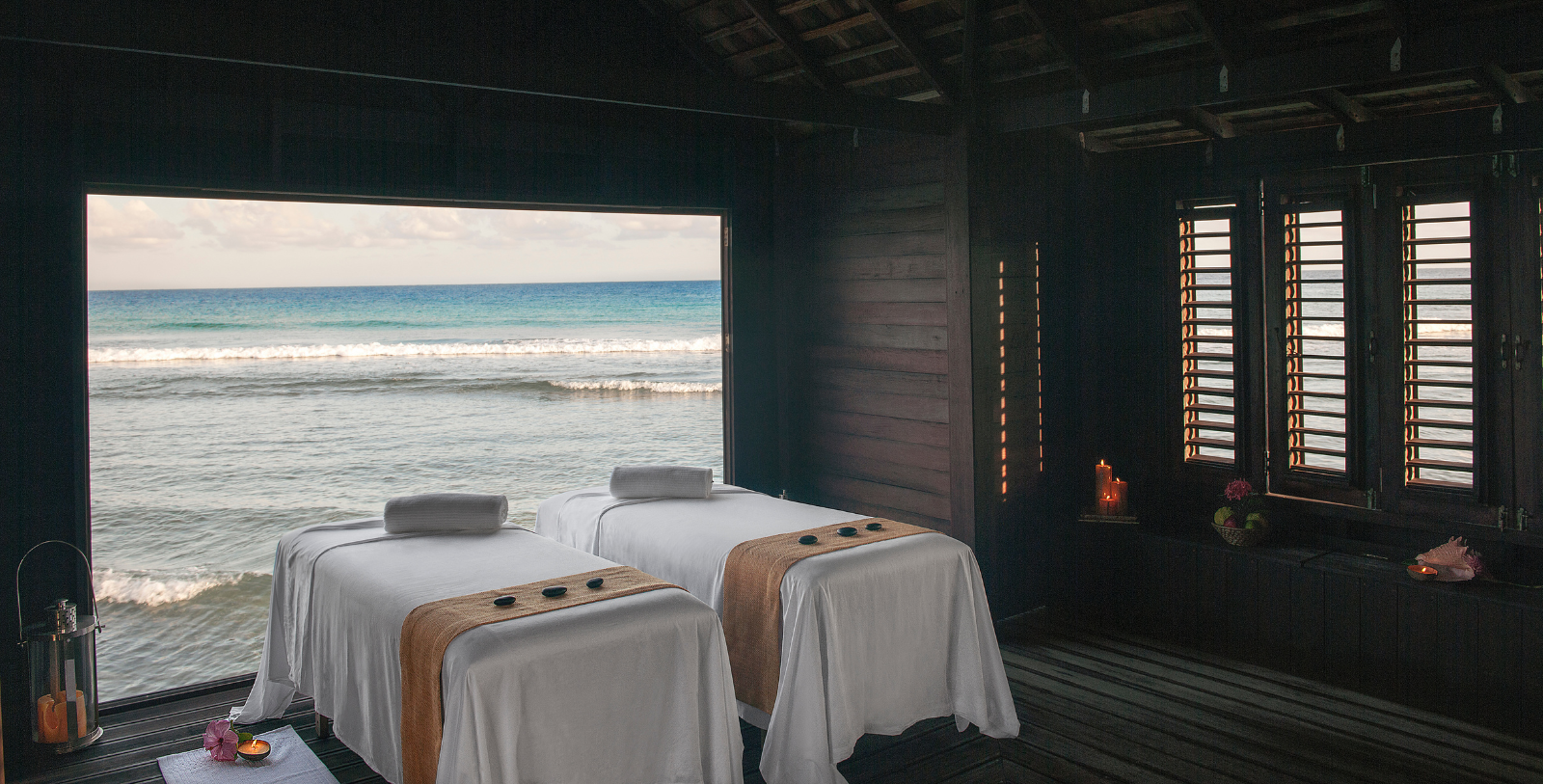 a massage beds with towels and candles on each side