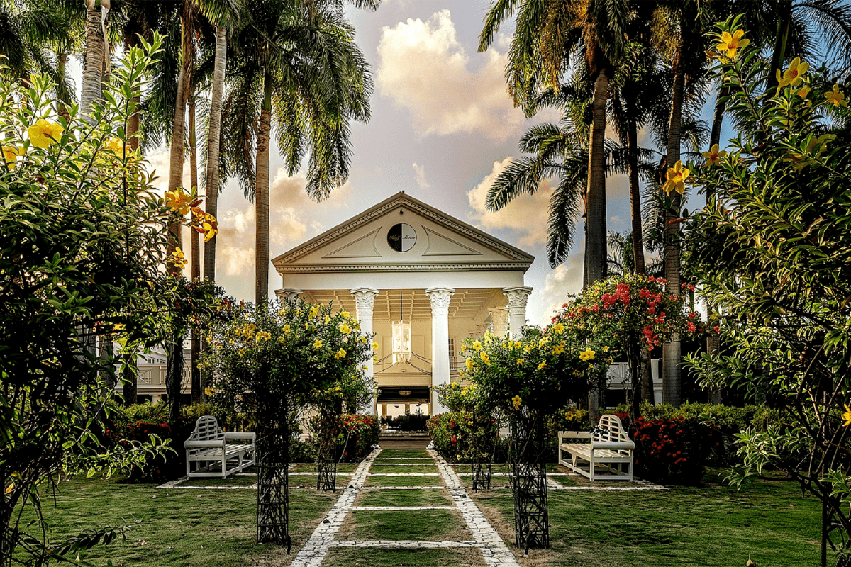 a white building with a clock and trees