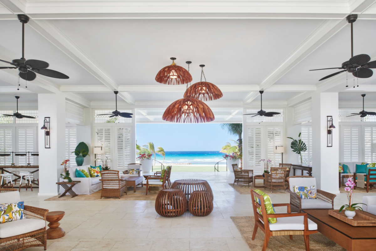 a room with chairs and tables and a view of the ocean