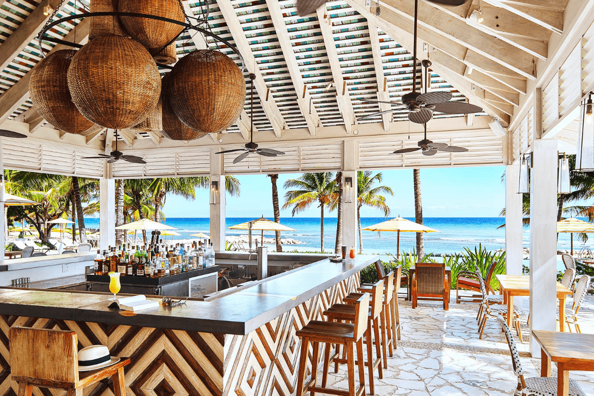 a bar with chairs and umbrellas on the beach
