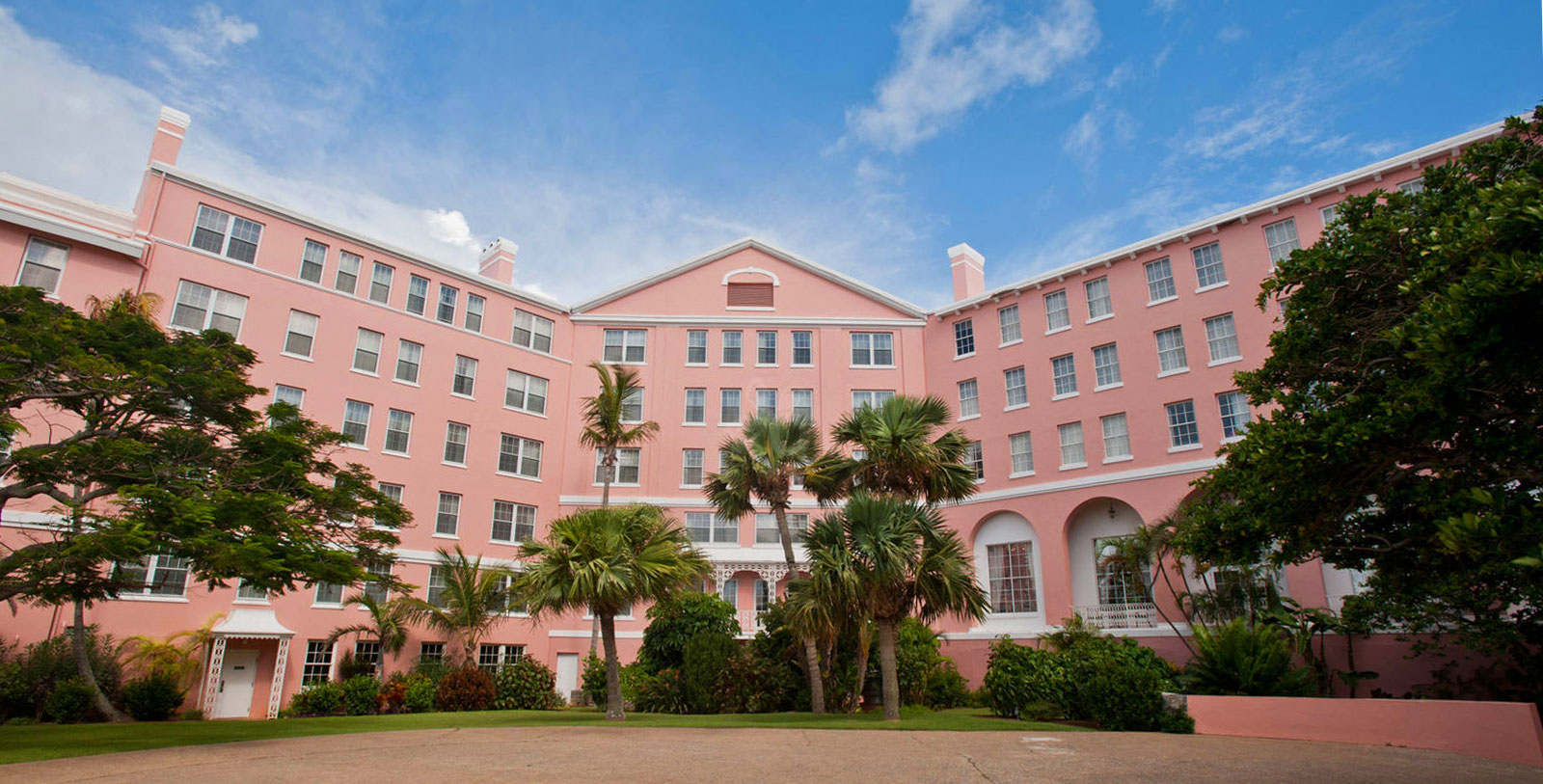 a pink building with palm trees