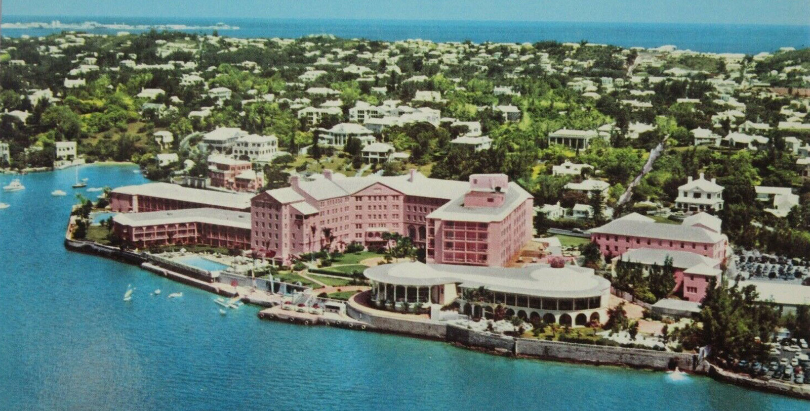 a large pink building next to a body of water