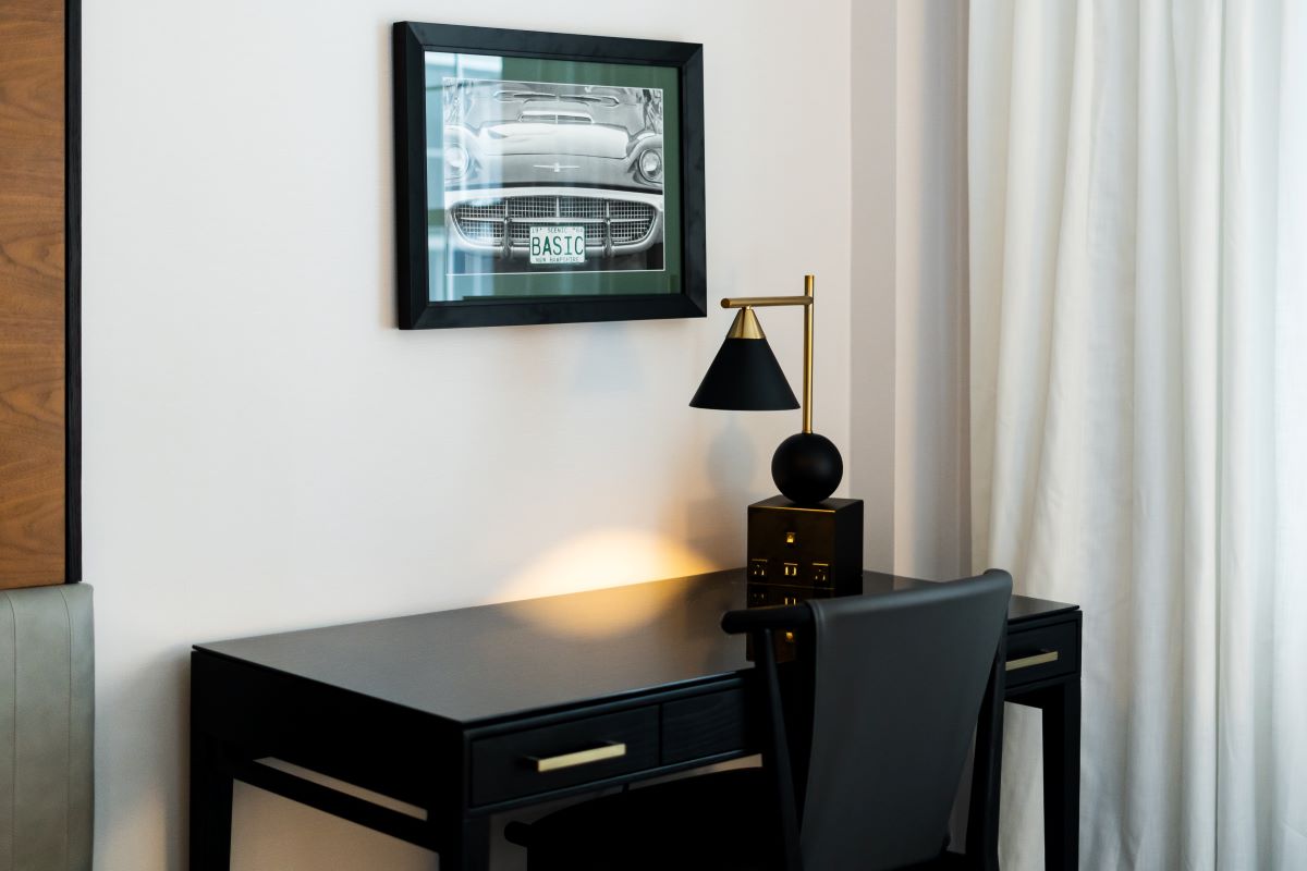a desk with a lamp and a picture on the wall