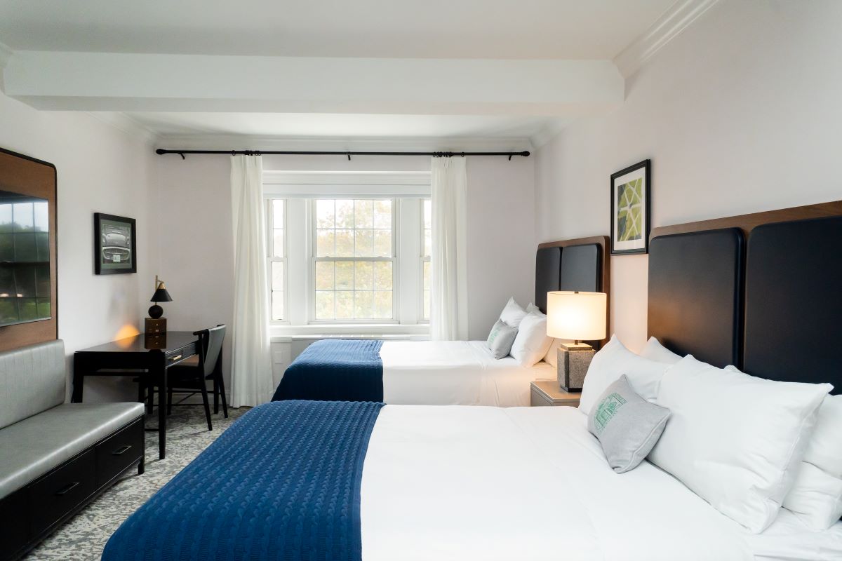 a room with two beds and a desk