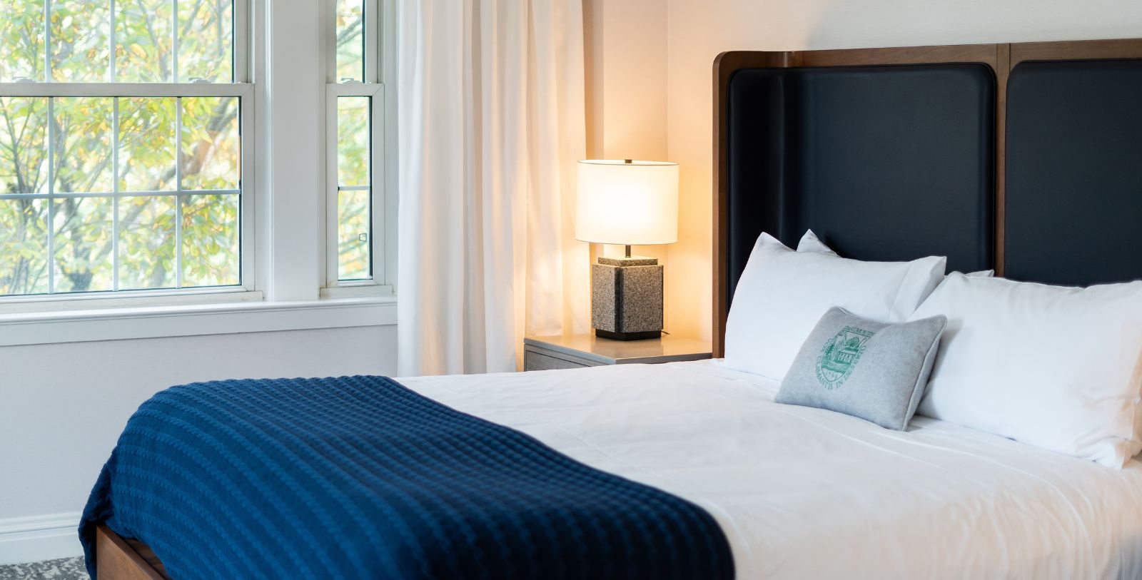 a bed with a lamp and a window