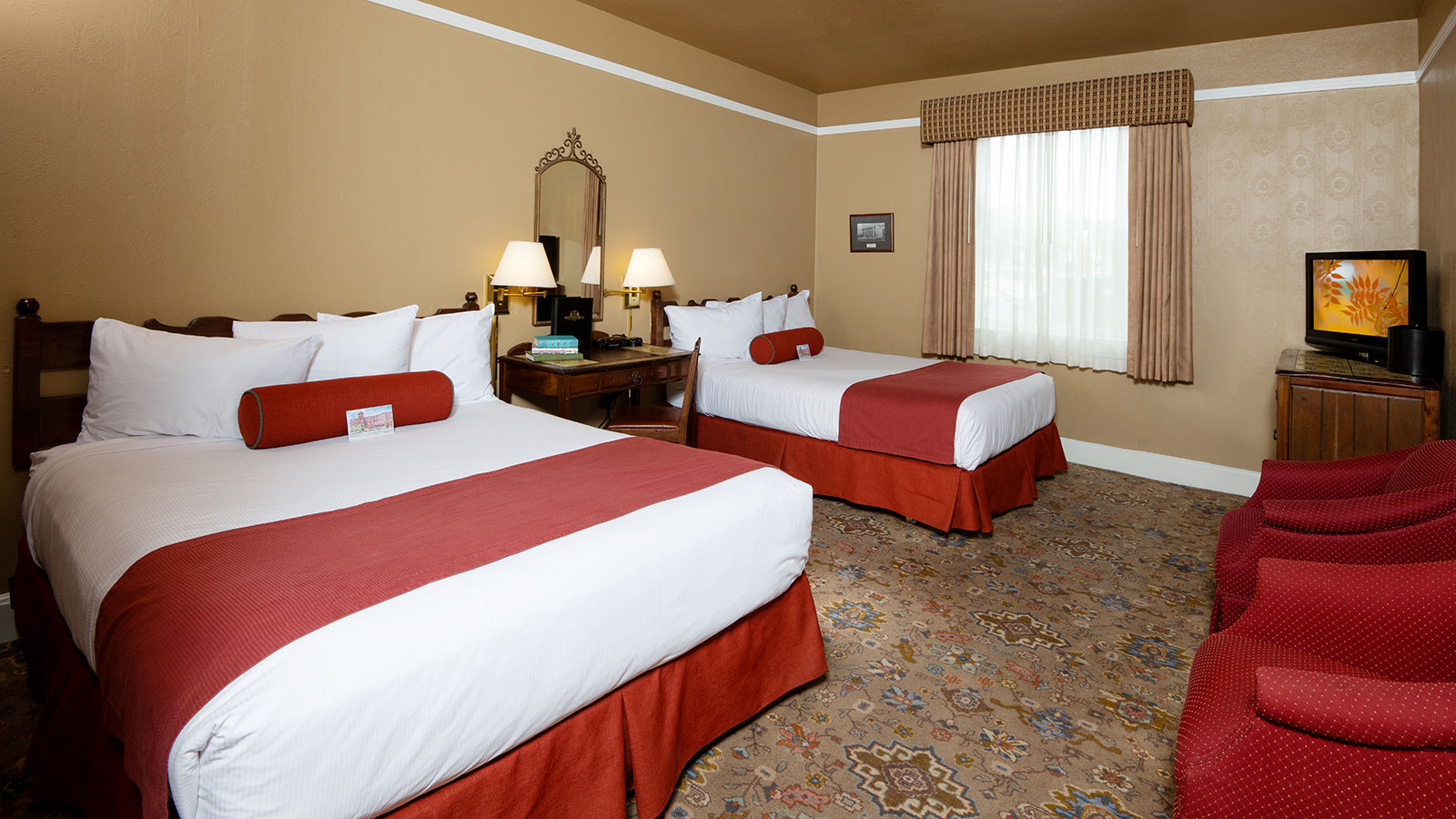 a room with two beds and a mirror