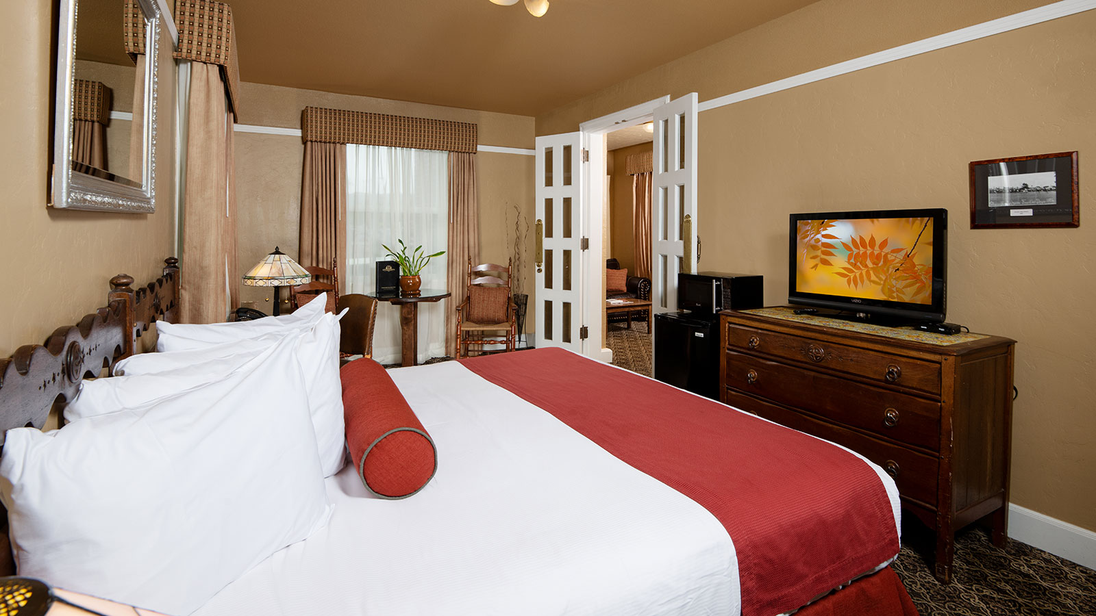 a bedroom with a red bed and a television